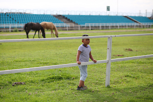 child on horse track 三月街赛马场